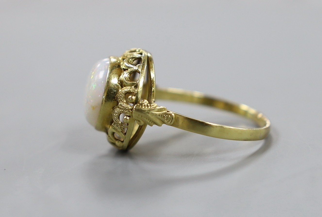 A 750 yellow metal and cabochon white opal set ring, with pierced setting, size U/V, gross weight 5 grams.